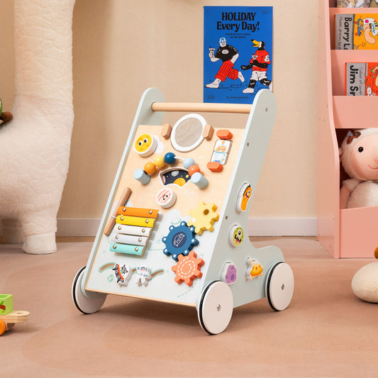 Green wooden baby walker with wheels in a nursery room setting