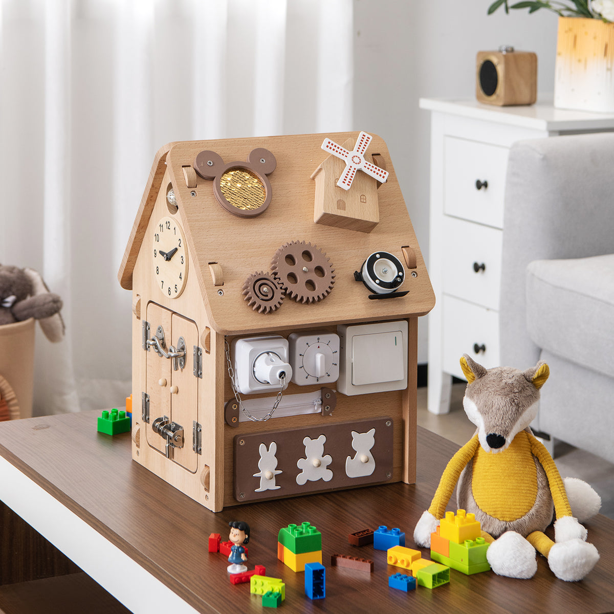 The learning toy placed on a table with toy blocks and a plush fox toy nearby