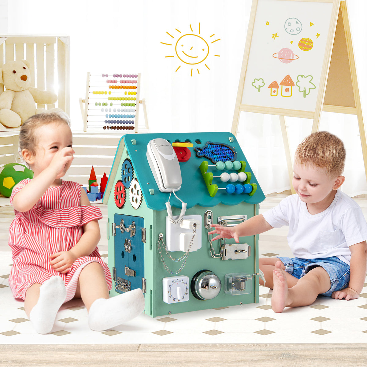 Two young children sitting on a play mat and interacting with the learning toy in a nursery