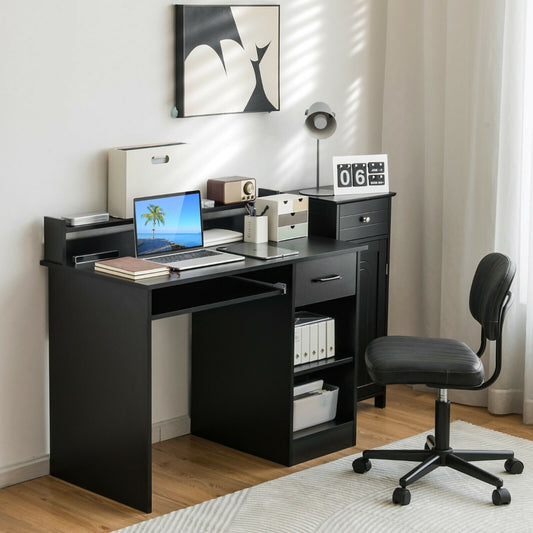 The office desk set up in a bright room with a laptop, lamp and chair for a home workspace
