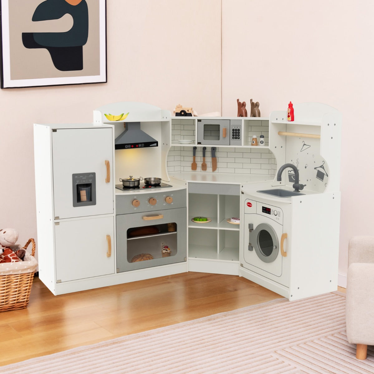The play kitchen set is shown in a room with a basket and artwork