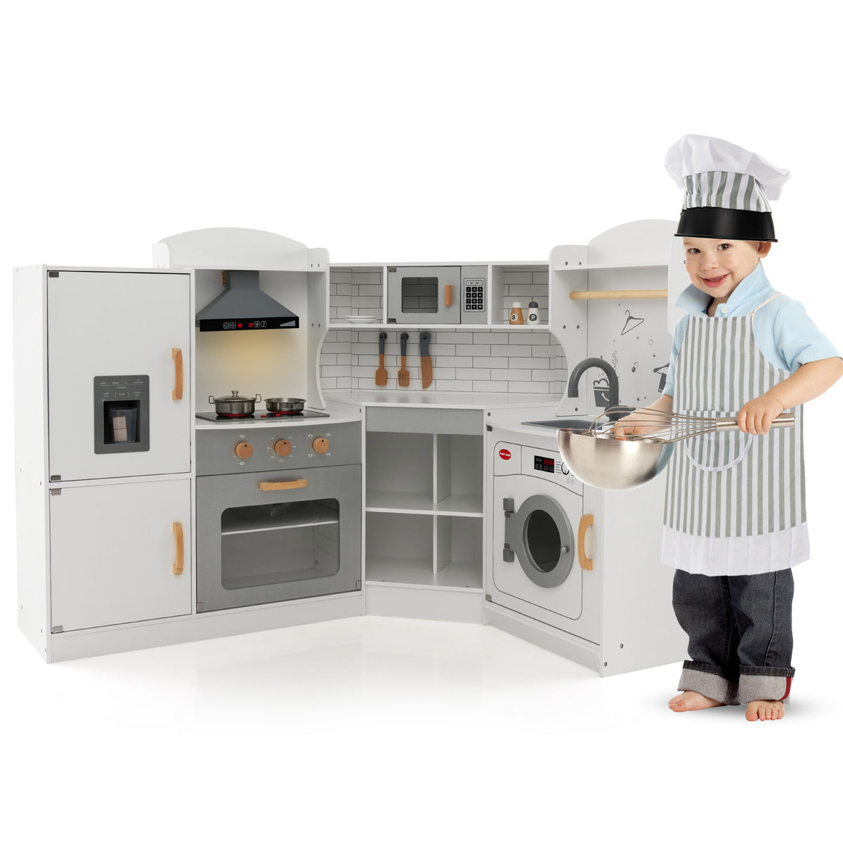 The play kitchen set next to a young boy wearing a chef hat and apron holding a mixing bowl