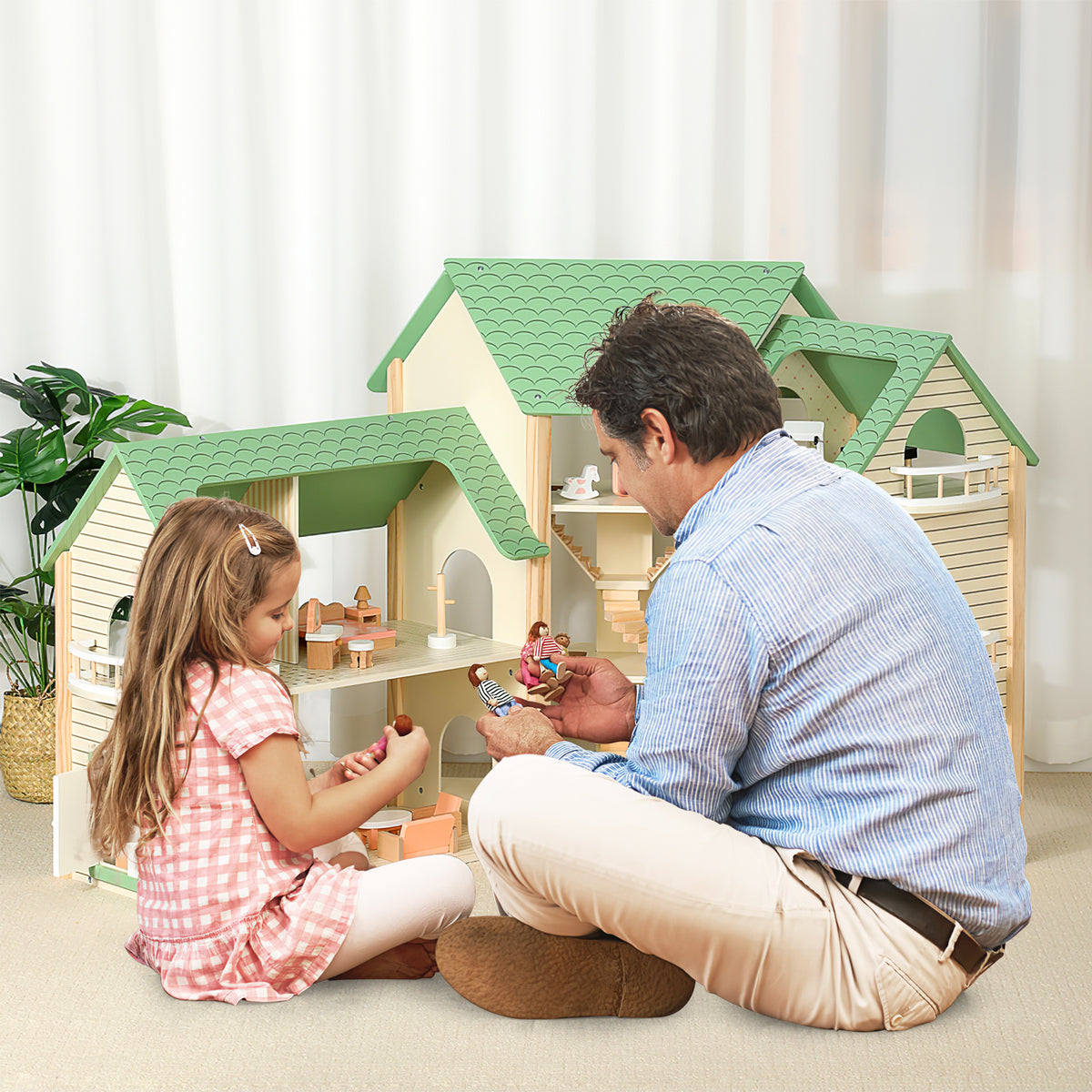 A father and daughter playing together with the wooden dollhouse