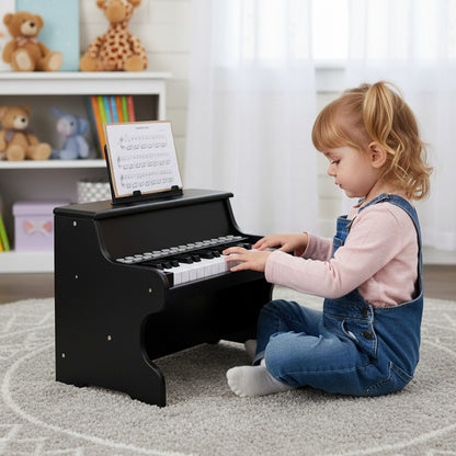A young child playing the black digital piano keyboard in a nursery room