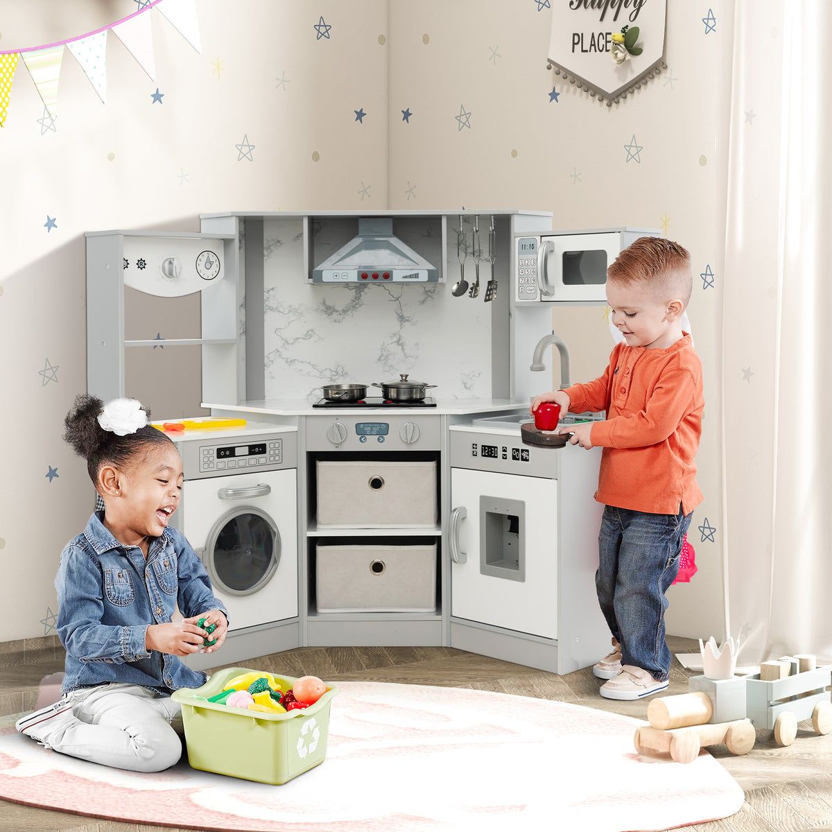The play kitchen set being used by two children in a bedroom with a rug and wooden toy train