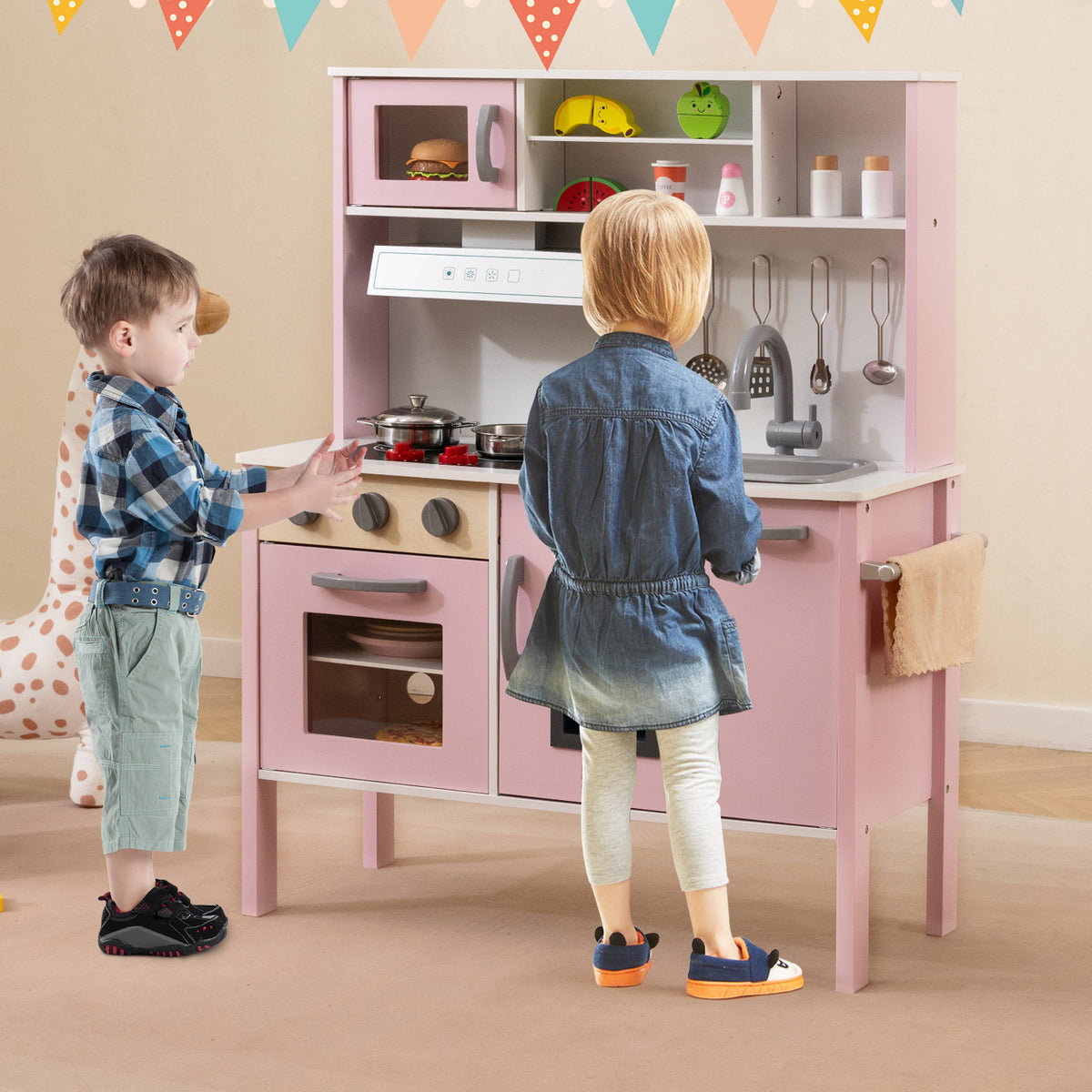 The play kitchen set being used by two children in a decorated room