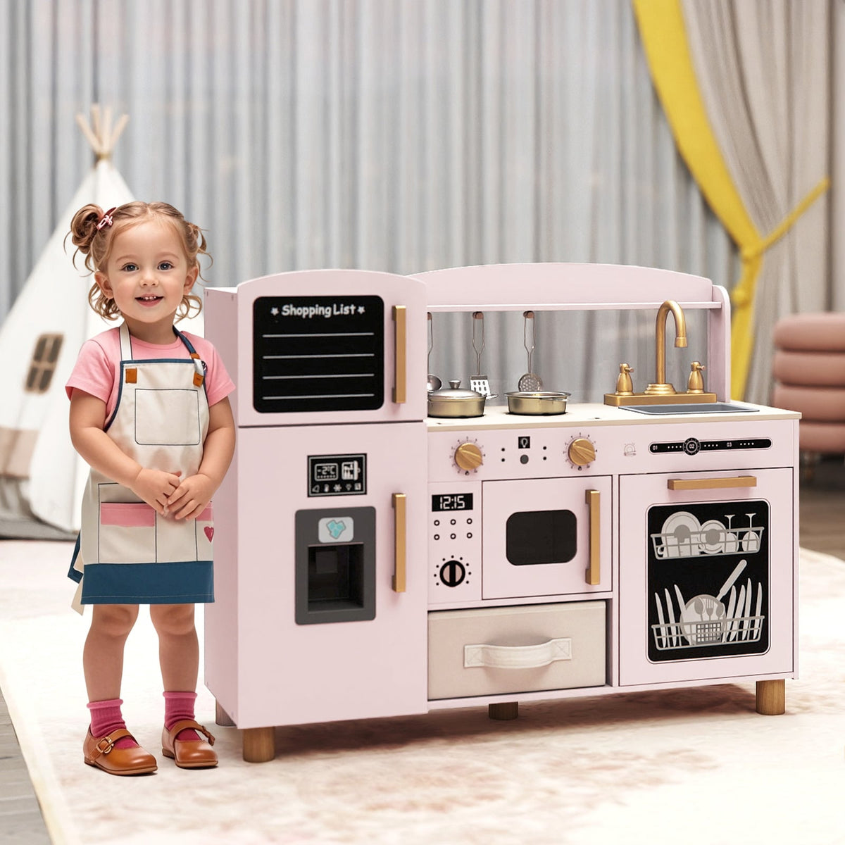 A young girl wearing an apron stands next to the pink play kitchen