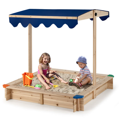 Children enjoying the wooden sandbox on a sunny day, with the blue canopy overhead