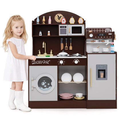 A young girl standing next to the wooden kitchen playset, smiling at the camera