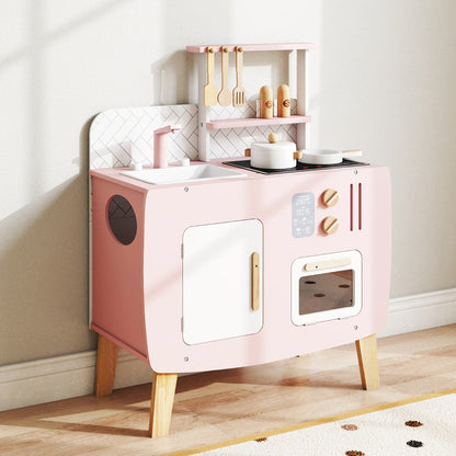 The play kitchen set placed against a wall in a bright room with wooden flooring