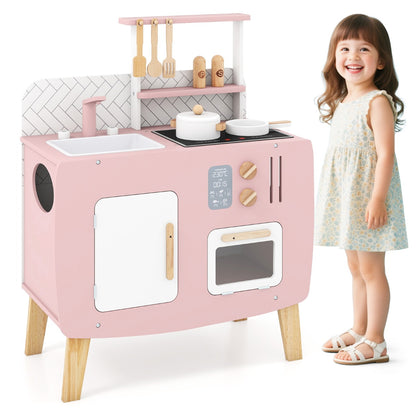 A young girl standing next to the play kitchen set to show its scale