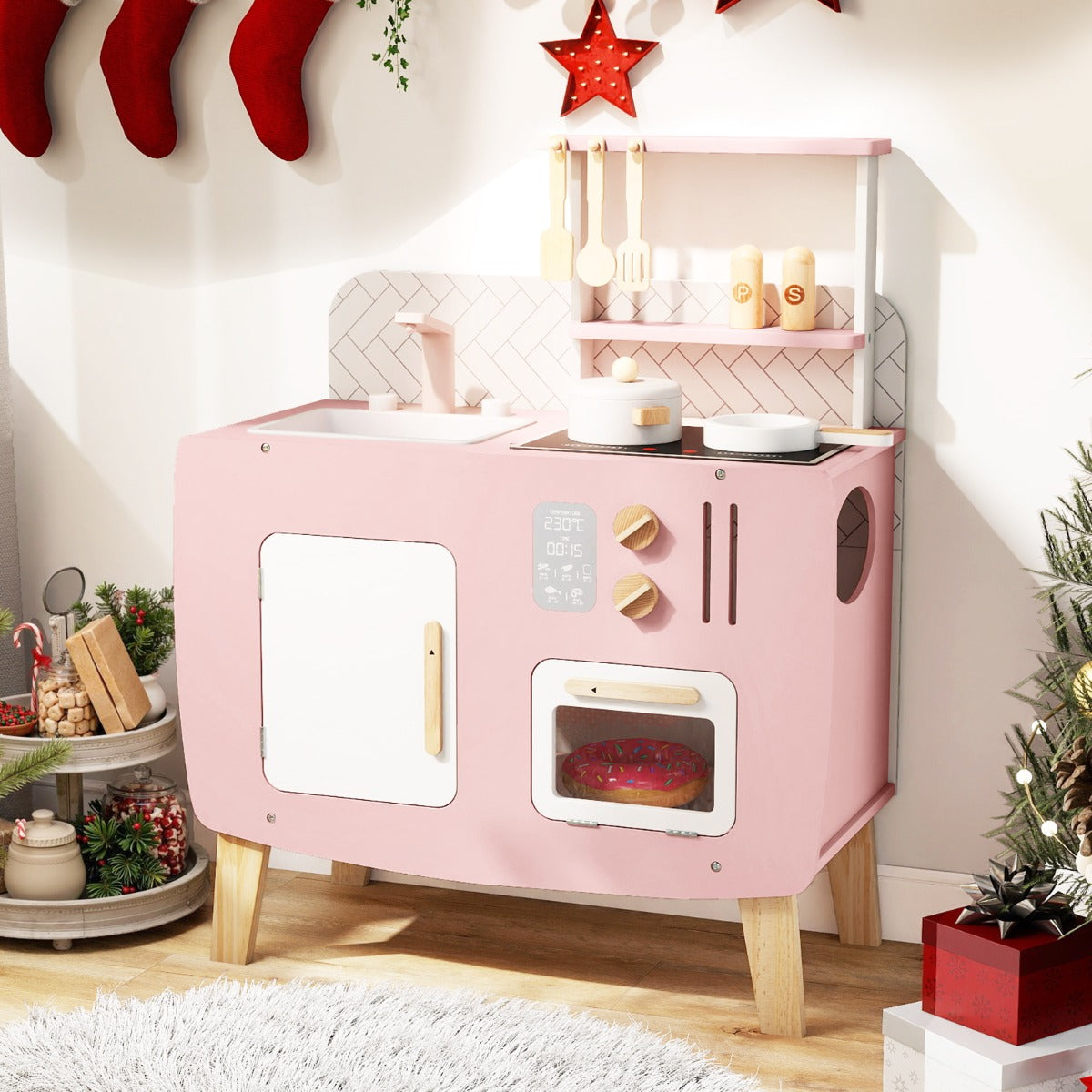 The play kitchen set decorated for Christmas with festive ornaments nearby