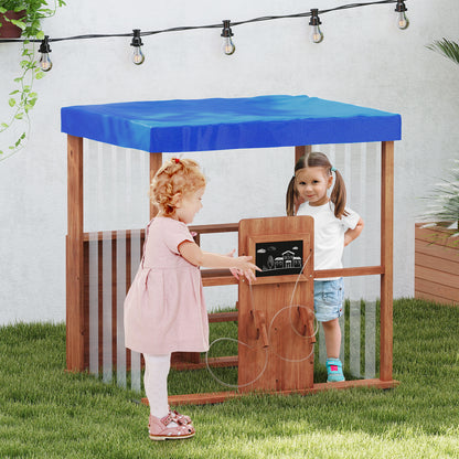 Two young children playing at the wooden outdoor gas station playset