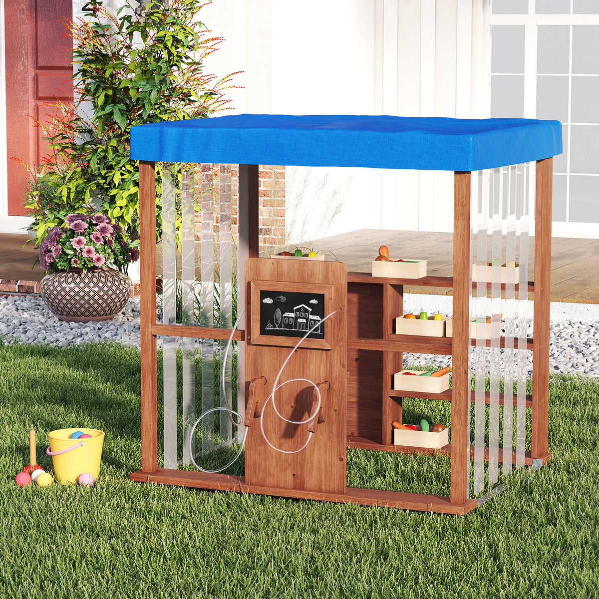 The wooden outdoor gas station playset in a garden with toys and plants