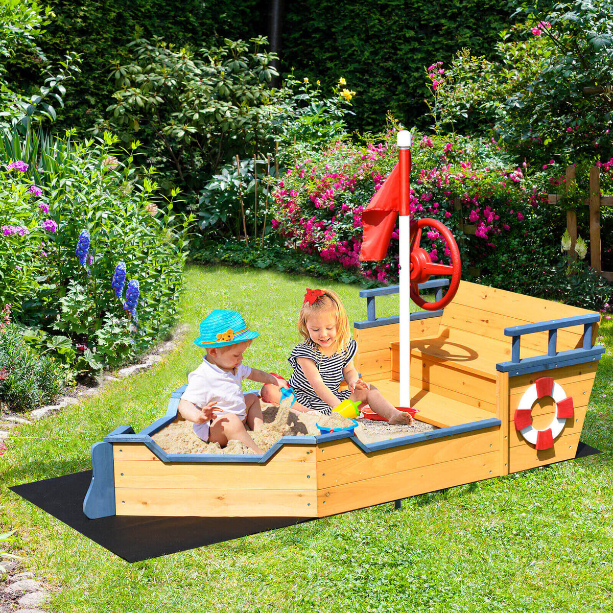 Two children playing in the wooden pirate sandboat sandbox in a garden setting