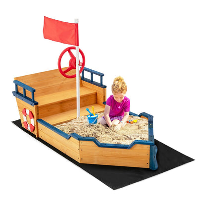 A girl playing in the wooden pirate sandboat sandbox, digging in the sand