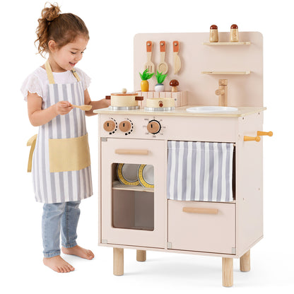 A young girl wearing an apron standing next to the play kitchen set
