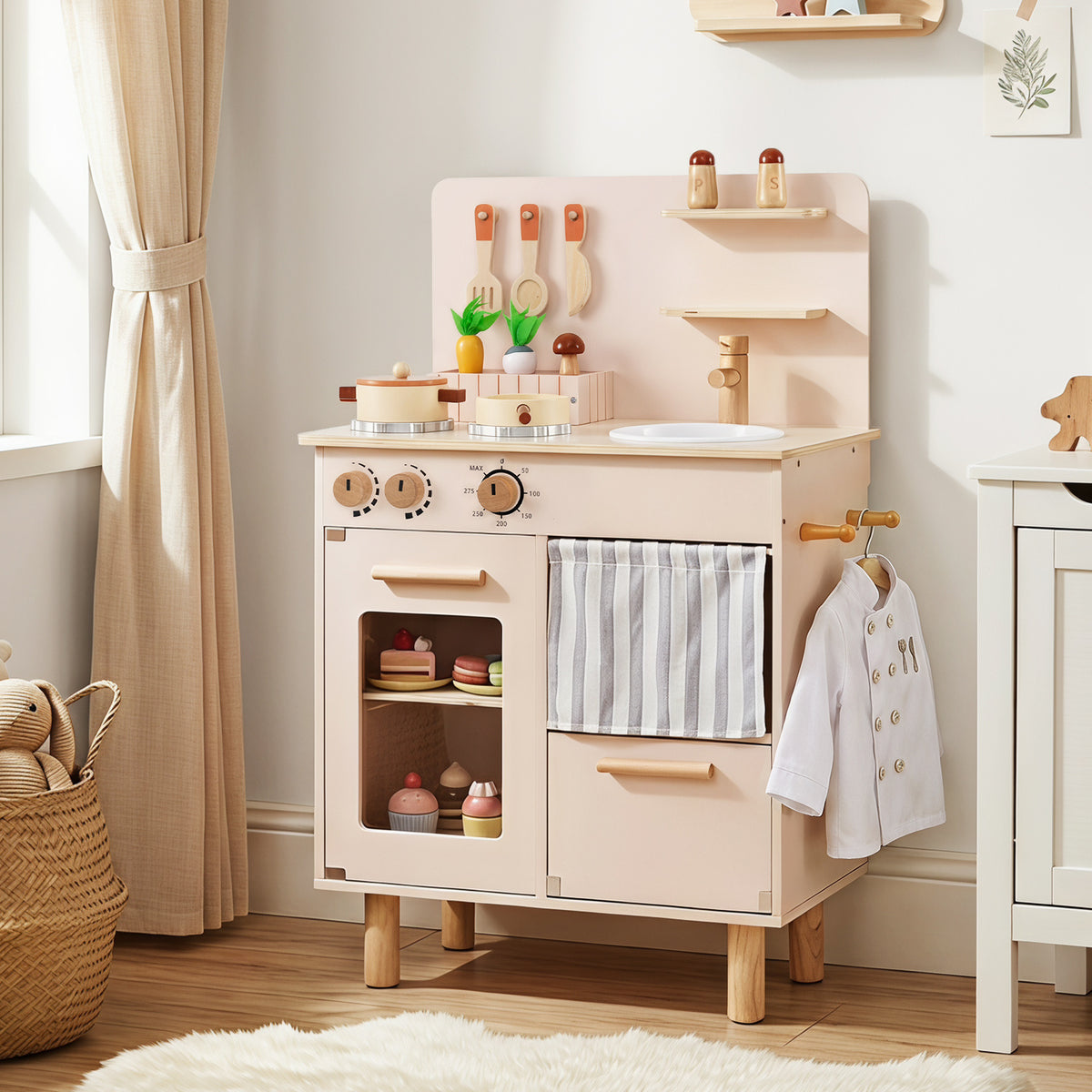 The play kitchen set placed in a bright room with a chef jacket hanging on the side