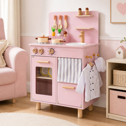 The pink play kitchen is shown in a child's bedroom next to a pink sofa and storage unit