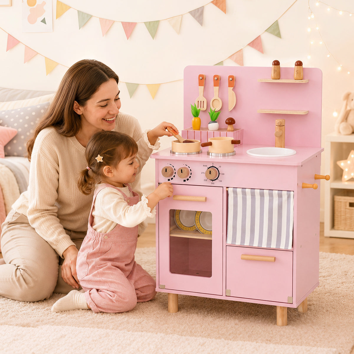 A mother and child play together at the pink wooden play kitchen