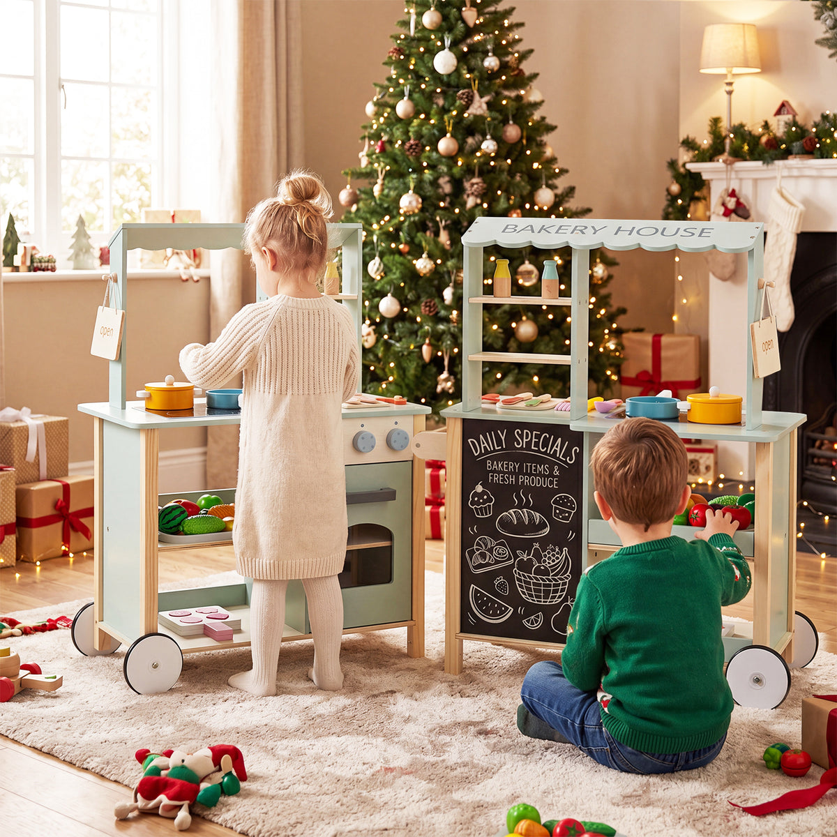 Two children playing with the wooden play kitchens in a festive room setting