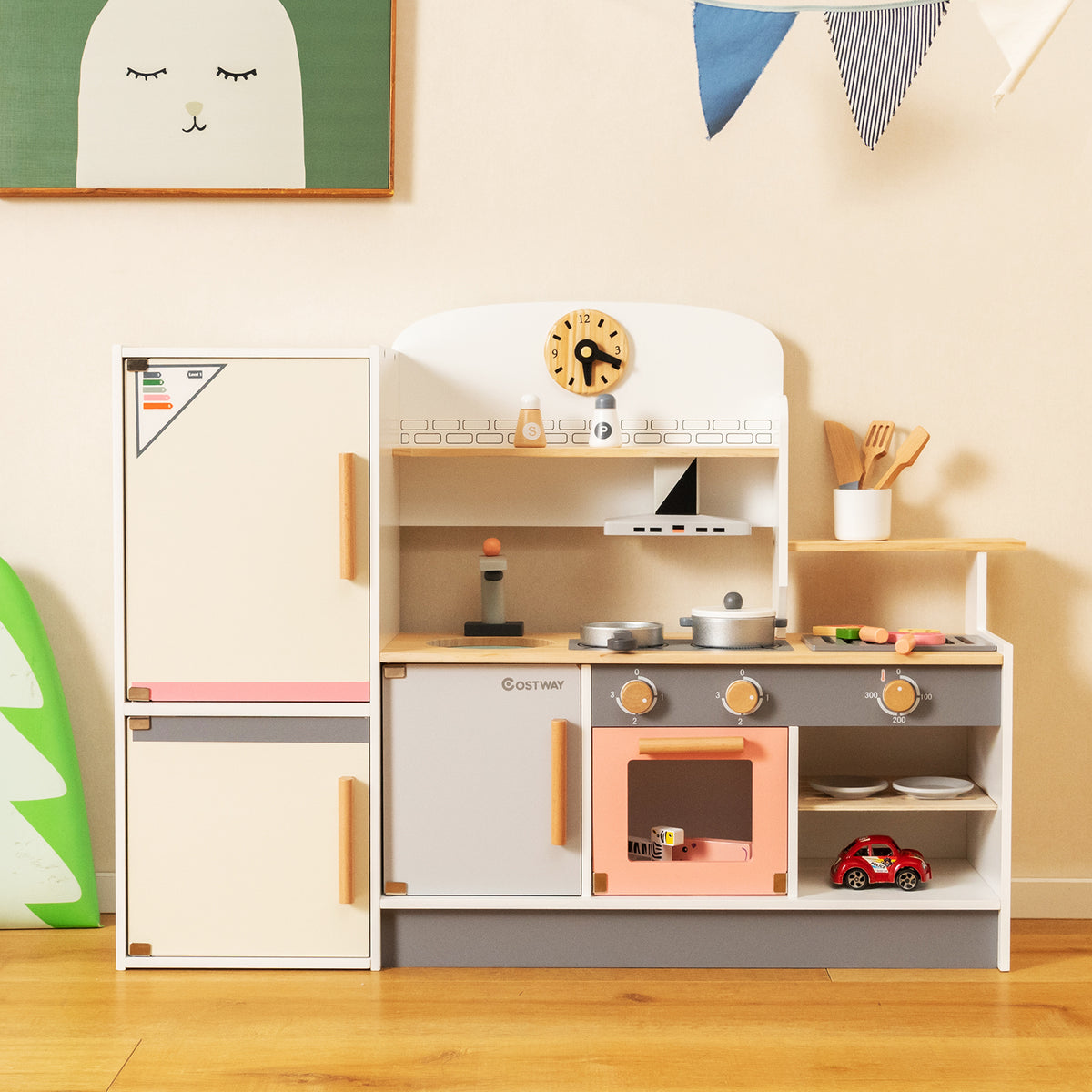 The wooden play kitchen has a fridge, oven, sink and hob