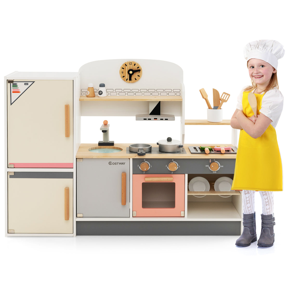 A child in a yellow apron stands next to the wooden play kitchen