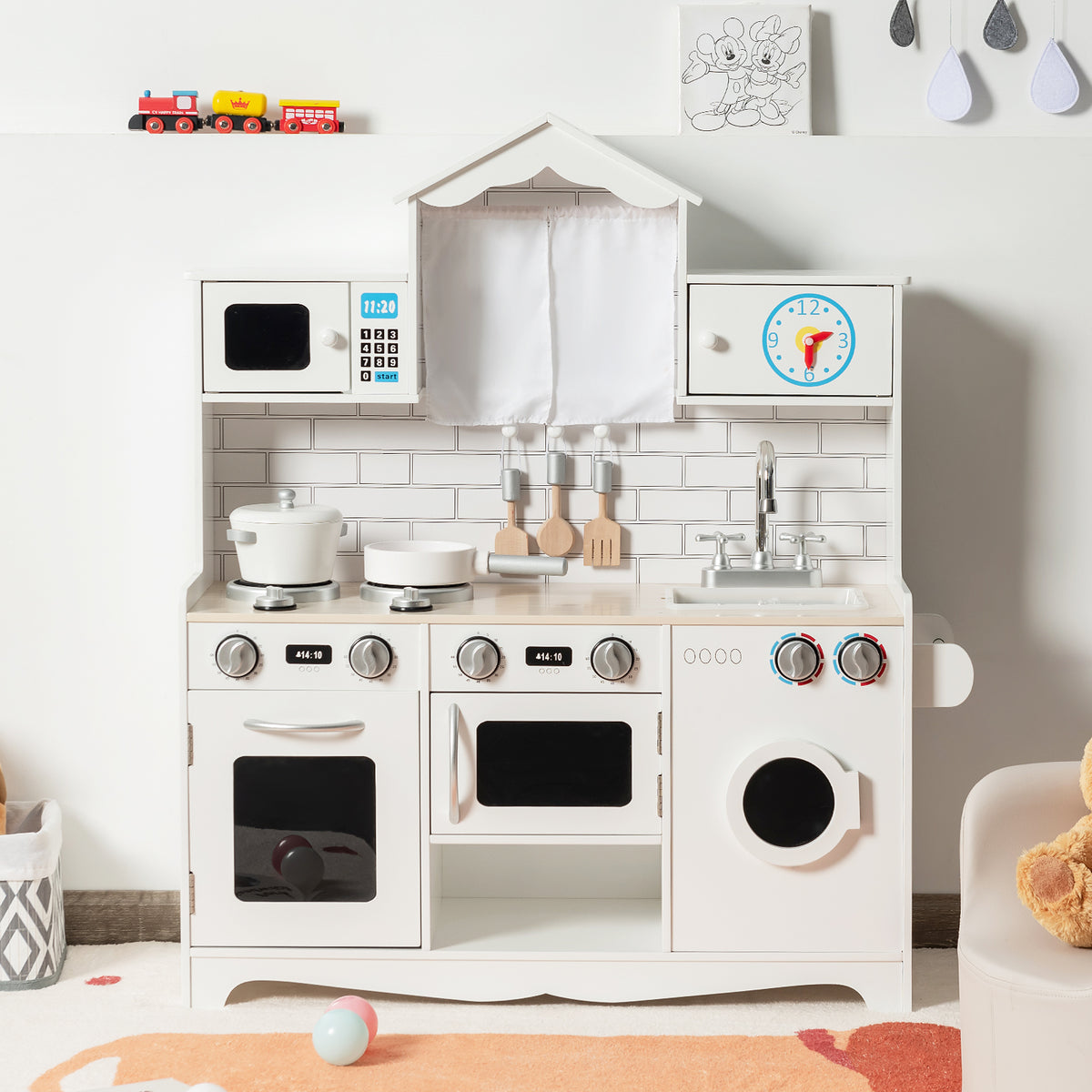 The wooden play kitchen set in a room with toys around it