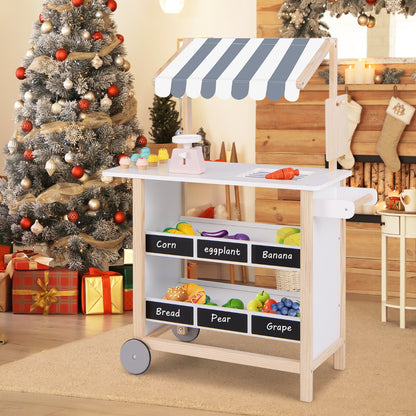The play kitchen set standing on a rug in a room decorated for Christmas with a tree and fireplace