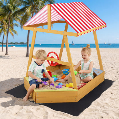 Children playing in the wooden ship sandpit on a beach
