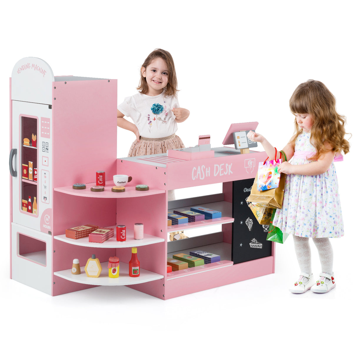 A girl hands shopping bags to another child at the pink wooden play kitchen