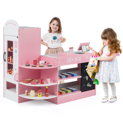 A girl hands shopping bags to another child at the pink wooden play kitchen