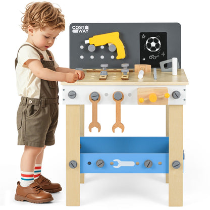 A young boy using the wooden toddler workbench playset, holding a toy tool