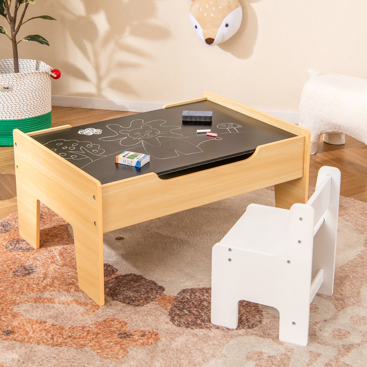 The wooden train table with the blackboard surface and a child's chair next to it