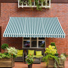 Green and white striped awning over a patio with chairs and plants on a brick wall background