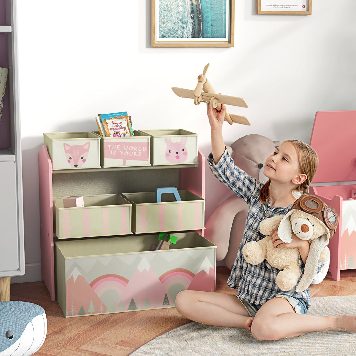 A young girl plays with toys next to the pink kids storage organiser in a room
