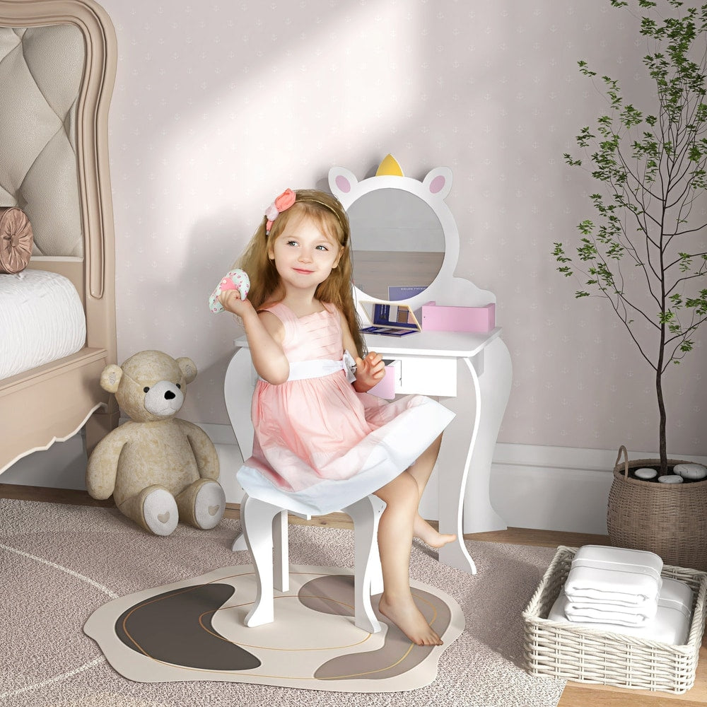 A young girl sits at the dressing table in a child's bedroom, playing with makeup